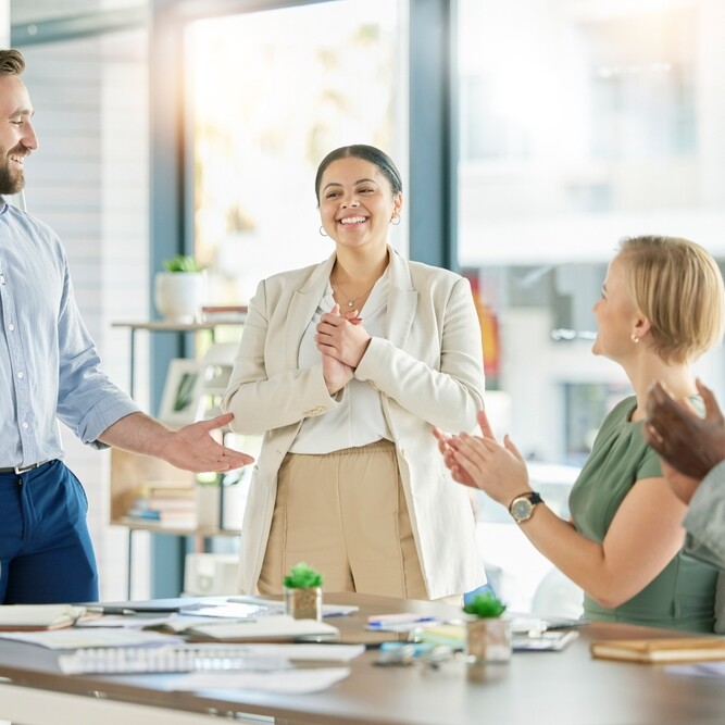 Admin assistant being promoted to executive assistant and being congratulated by her colleagues
